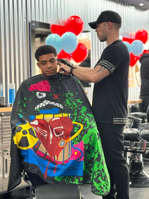 Grim edging a client's hairline with clippers