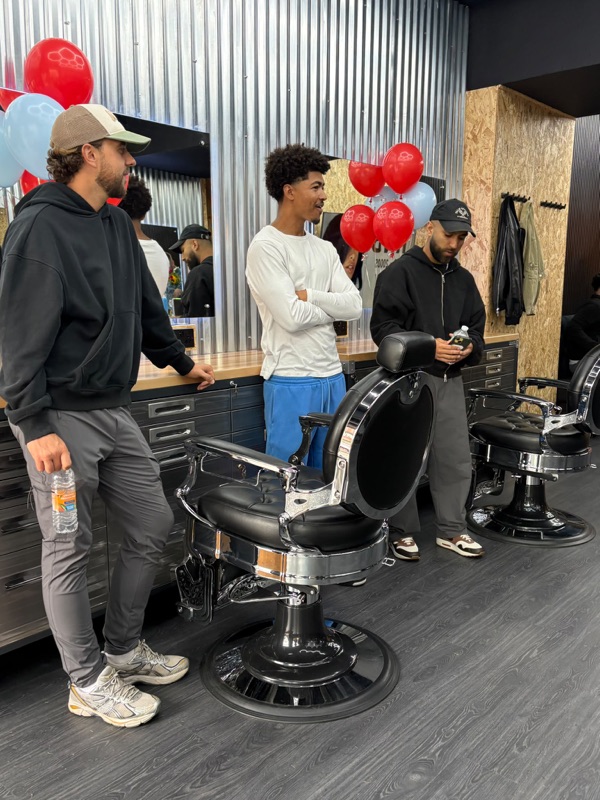 Barbers gathered around the chairs inside the new shop