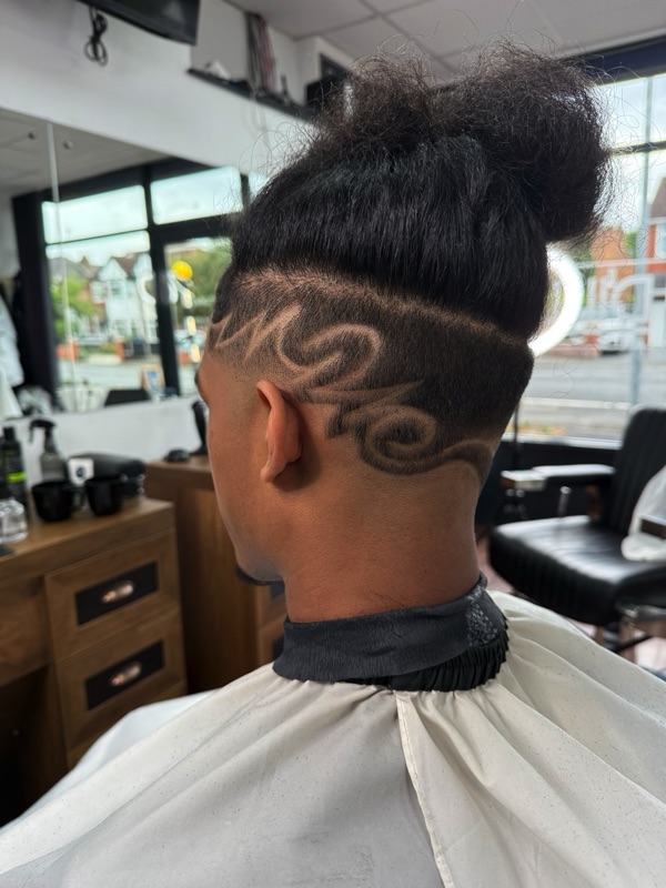 Freehand swirl pattern razored into the side of a client's hair